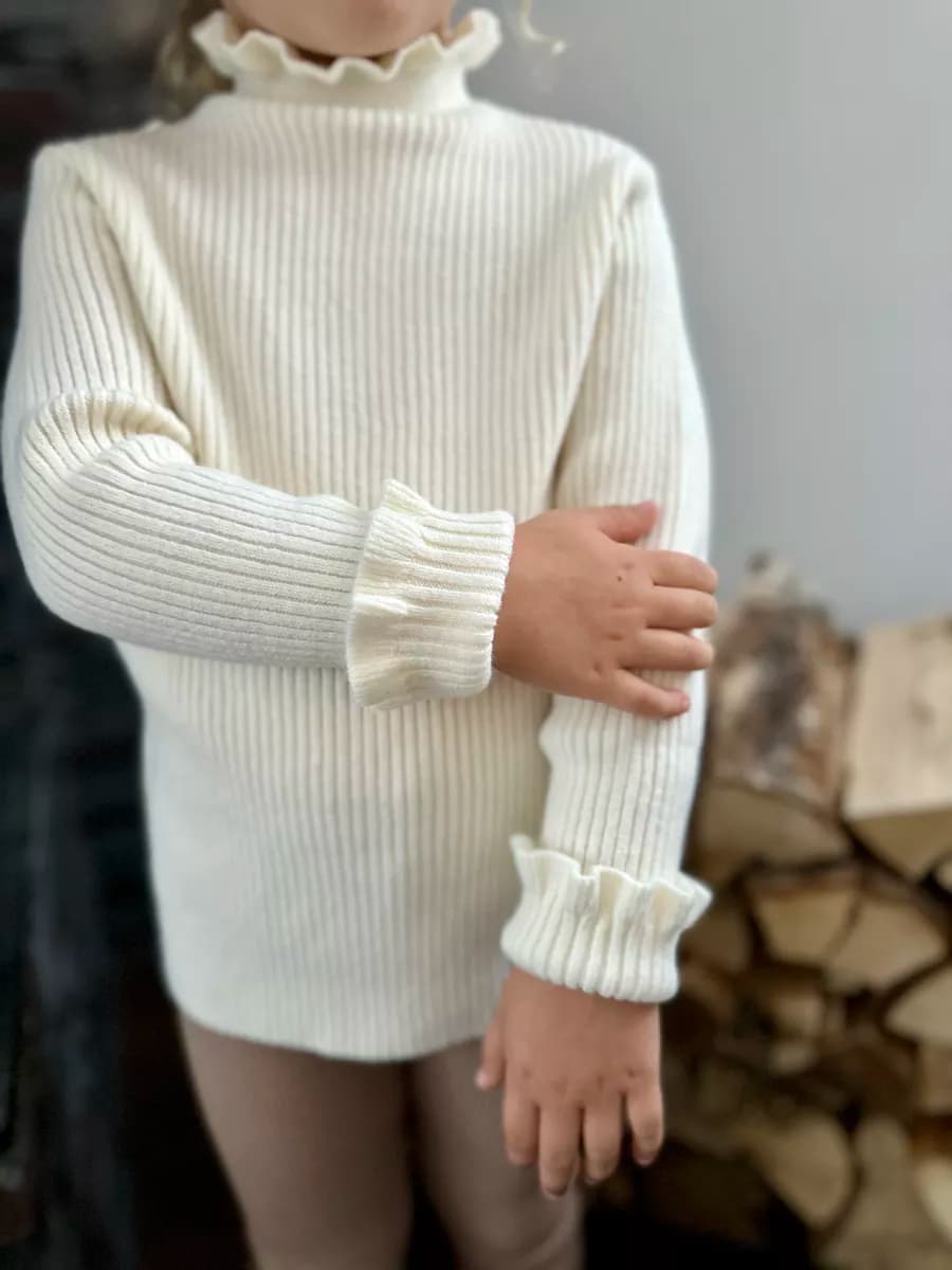 Вязаный свитер водолазка в рубчик с рюшами