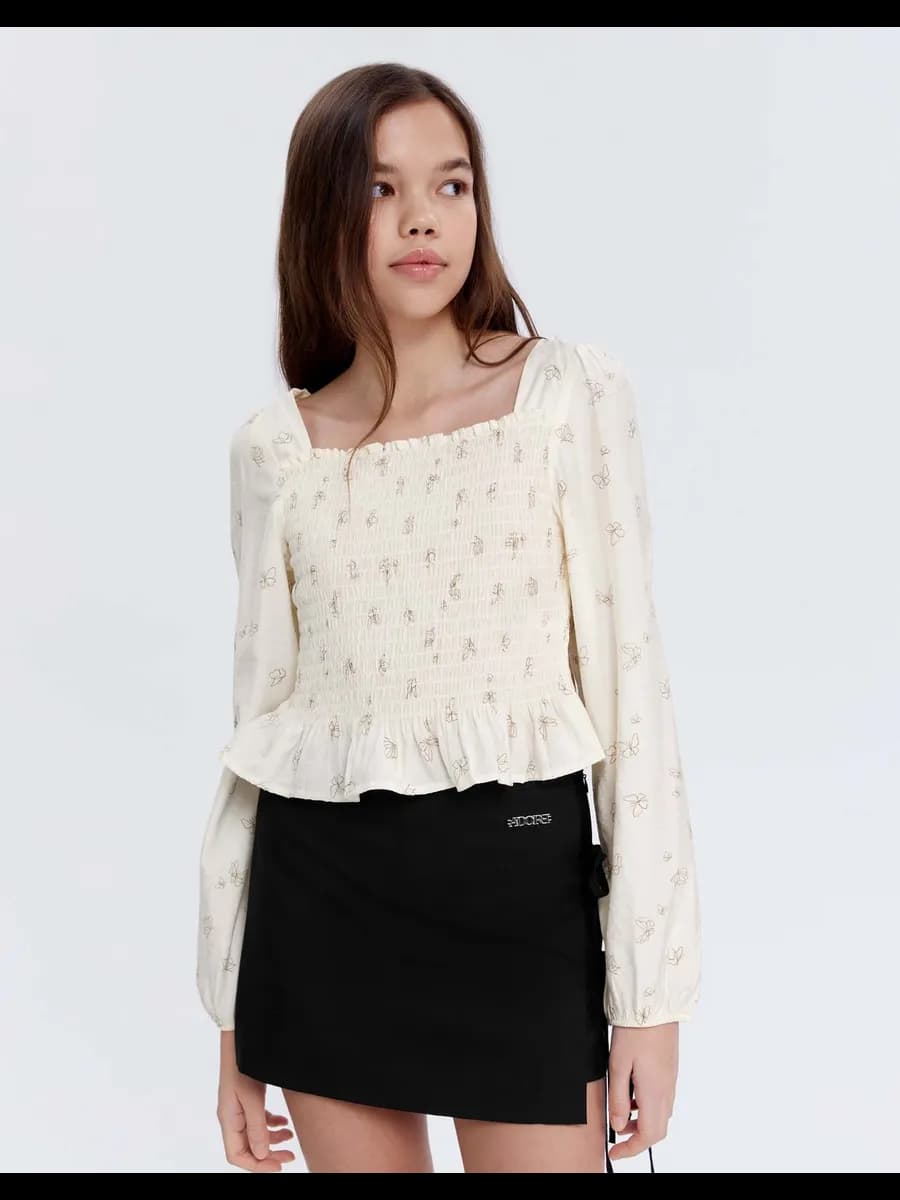 Молочная блузка с принтом и баской